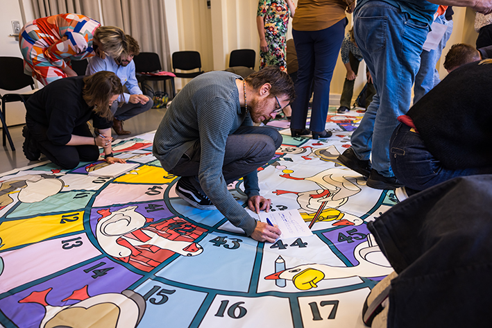 Een van de deelnemers maakt aantekeningen tijdens een spelletje Kânseboerd.